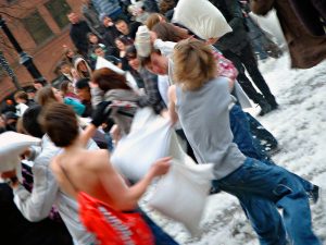 People having a pillow fight outdoors are shown here