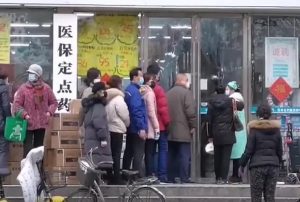 "Citizens of Wuhan lining up outside of a drug store to buy masks during the Wuhan coronavirus outbreak" by China News Network is licensed under CC BY 3.0