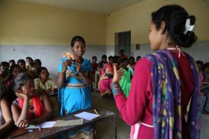 A woman teaches reproductive health to a group of girls in a classroom in Raniganj, Bihar, India.