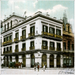 A turn of the century color picture of the Pyramides Hotel with a horse-drawn carriage waiting outside.