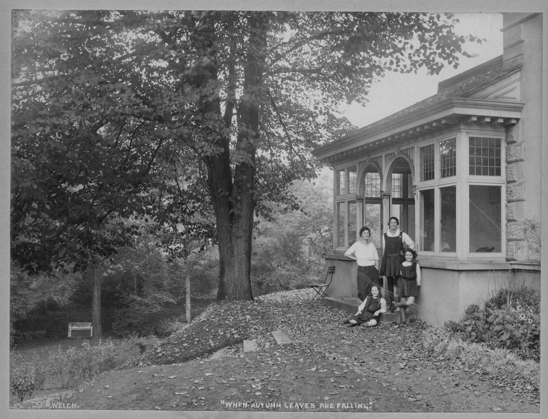 A photograph of the side of Lennoxvale, JMcC's house in Belfast, with his four daughters. Helen sophisticated (not in pinafore), and Amélie next to her – the 2 “little” ones in front, Joan sitting and Peggy standing. The picture was taken around 1922 by Robert John Welch.