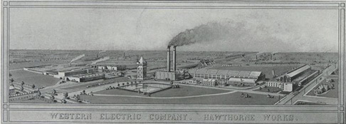 An image of a factory complex with two functioning smokestacks and a number of buildings is shown.