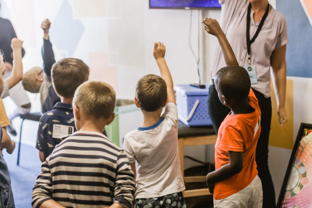 Children raising hands to answer question