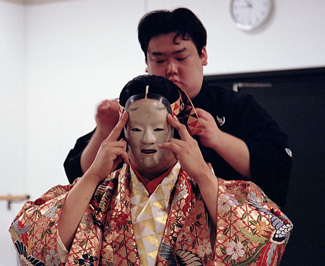 Actor donning mask at a Noh workshop in Copenhagen, Denmark, 2010