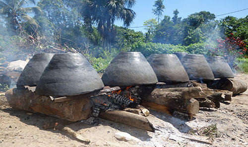 Image of clay cooking pots on a fire in Suriname; the design is similar to the culinary shoe pot.