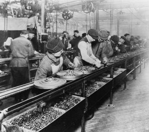 Image of assembly line workers completing their specific tasks.
