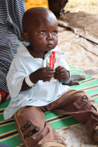 Child consuming a small packet of ready-to-eat-therapeutic-food (RUTF)