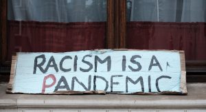 A sign reading, Racism is a Pandemic.