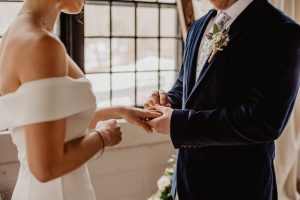 A bride and groom exchange rings at their wedding.