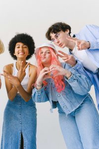 A group of friends throwing up different peace and love gestures towards the camera.