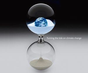 Hourglass with earth in the top bulb and sand flowing to the bottom bulb.
