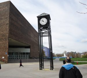 A tall clock on a college campus.