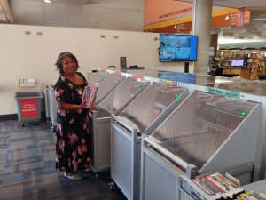 Elisa Hernandez demonstrating the automatic book sorting machine at her library.