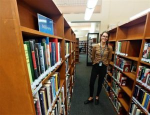 Danielle Davis standing in the Military section of the library.