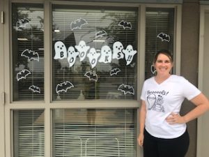 Shannon Rapo standing in front of a decorated library window.